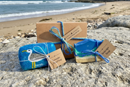 Coastal gift set with one blue colour felted soap with a seagull image needlefelted onto it and one seascape soap which depicts the beach and ocean waves. 
They come in a gift box tied with blue & turquoise jute string. The picture has a beach background. 
The soaps are handmade, natural & palm oil free. Packaging is all plastic free. 
An ideal eco friendly spring & summer gift for friends, family and beach & ocean lovers. 