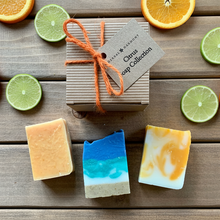 Load image into Gallery viewer, A gift set in a square cardboard box containing 3 half size soaps (min 50g each), one May Chang &amp; Lemon soap, one seascape soap (lemongrass &amp; lime scent), one patchouli &amp; Orange soap. The gift set is tied with orange jute string and has a brown recycled paper tag attached which says Citrus Soap Collection by Herbal Harmony. 
The soaps are all handmade, natural and vegan. The packaging is all eco friendly and plastic free. Ideal spring and summer gift for women and friends. 
